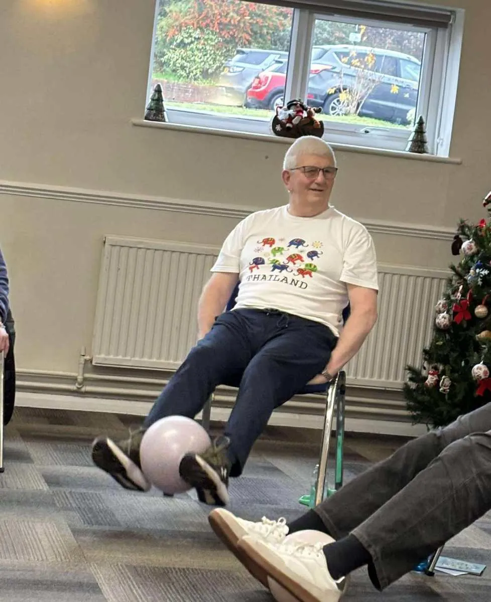 Seated exercise with a soft ball during an Over 60s Keep Moving session, Willing Spirit Exercise